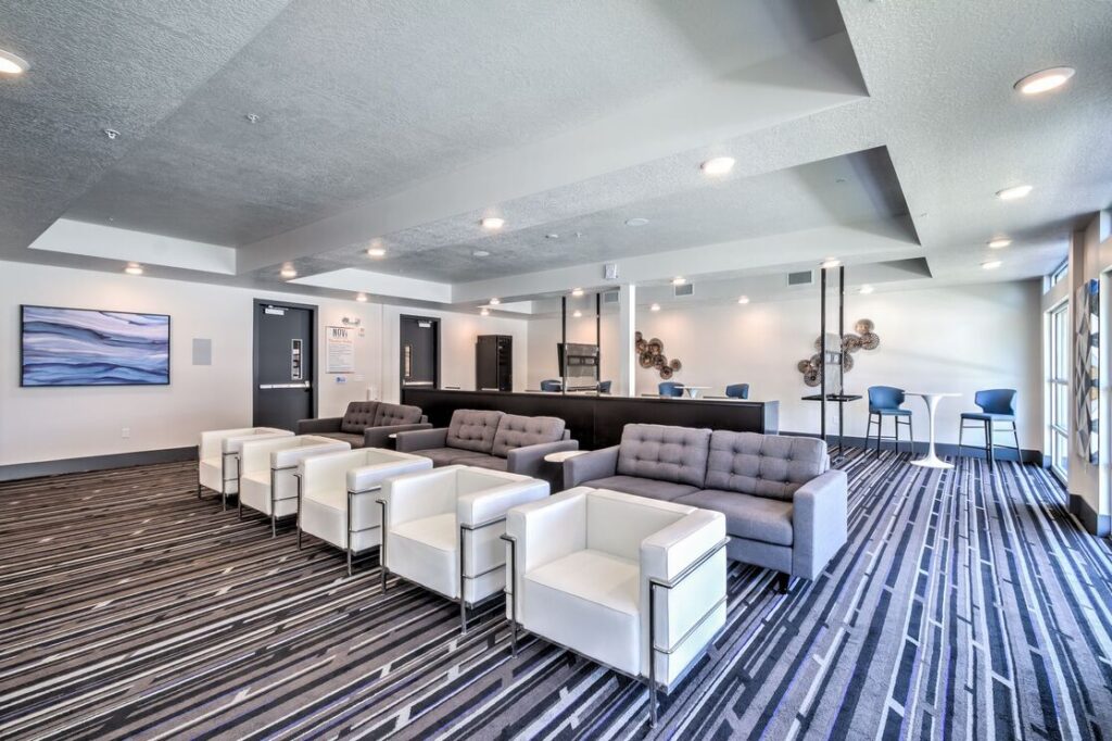 clubhouse interior and seating area. grey couches and white leather modern chairs