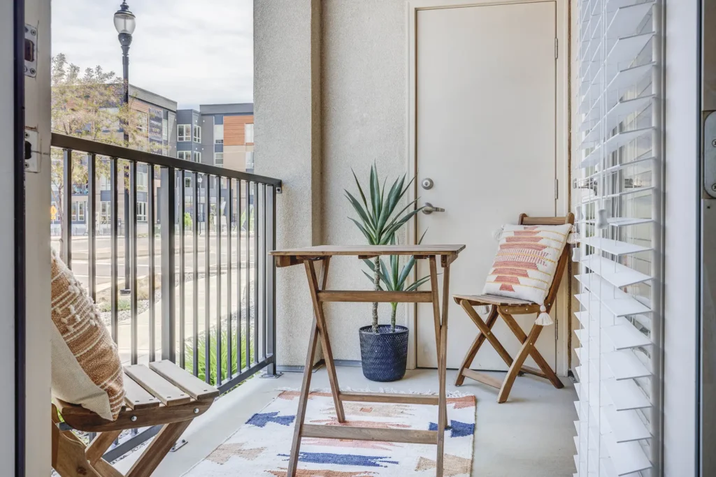 balcony view with neutral colors for decors, two chairs and a small table