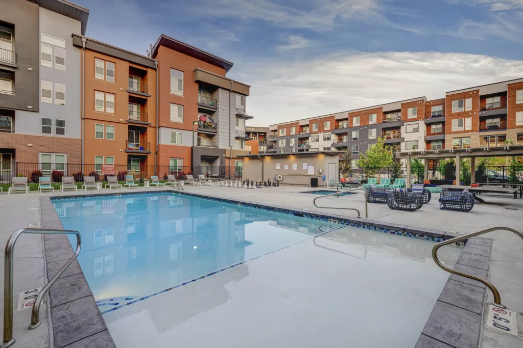 pool courtyard with lounge chairs, giant chess, hot tub, ping pong table, and a shade structure
